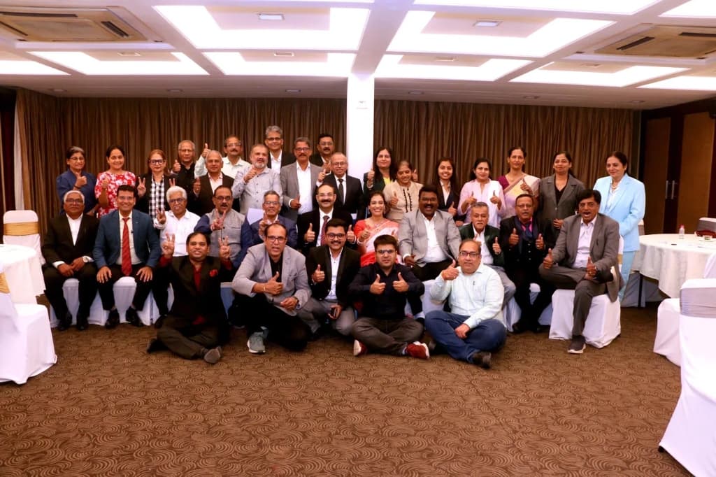 WiseWealth community — group of clients and advisors at a seminar event, many giving thumbs up