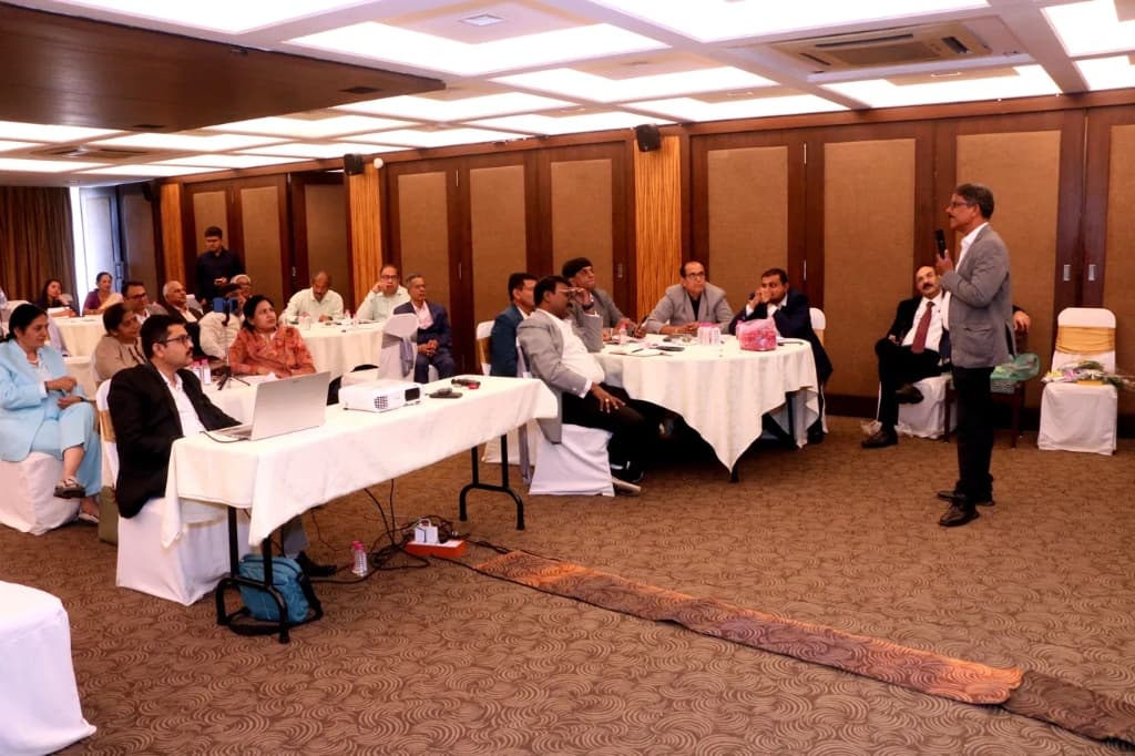 Financial seminar — attendees seated at white-cloth tables with presenter at front of hotel ballroom